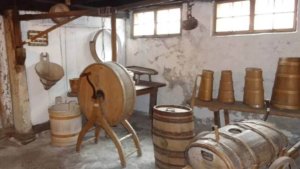Darstellung einer alten Sennküche mit Butterfass und Käseformen im Heimatmuseum Oberstdorf