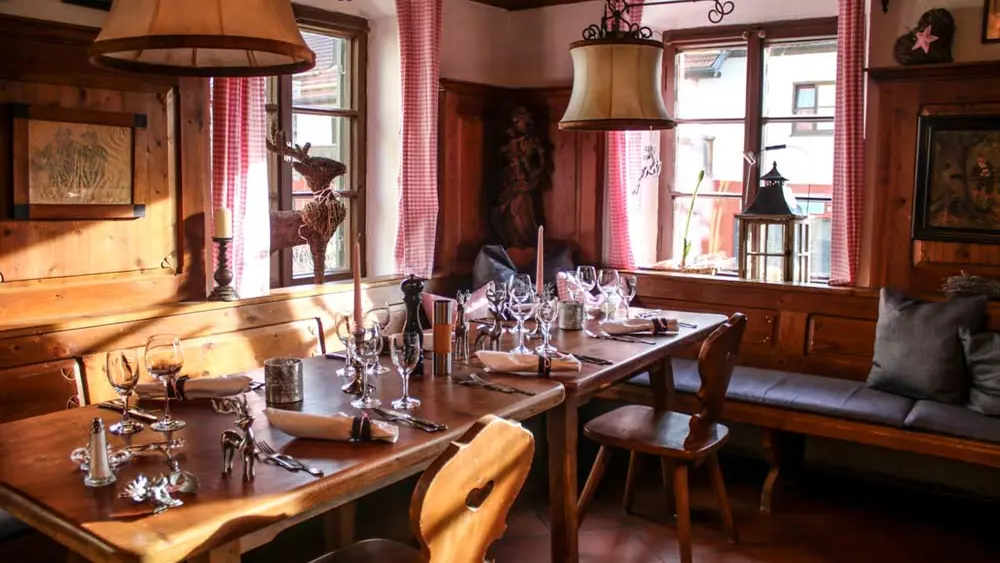 Gastraum mit eingedecktem Tisch im Restaurant Fischerrosl in Münsing