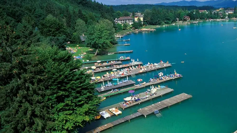 Luftaufnahme eines Badebereichs mit Stegen am Klopeiner See