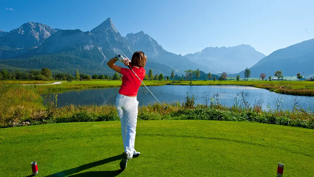 Golferin beim Abschlag auf dem Golfplatz Tiroler Zugspitze in Ehrwald