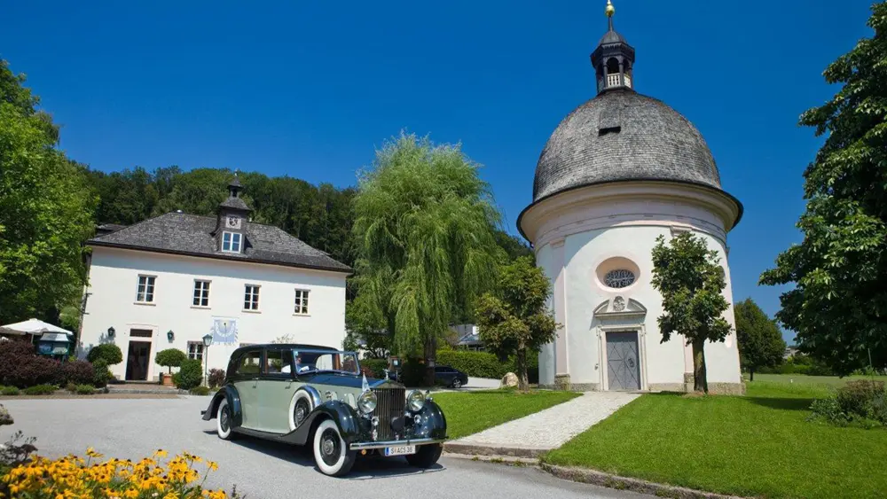 Oldtimer vor dem Restaurant Pfefferschiff und der Kapelle in Hallwang-Söllheim