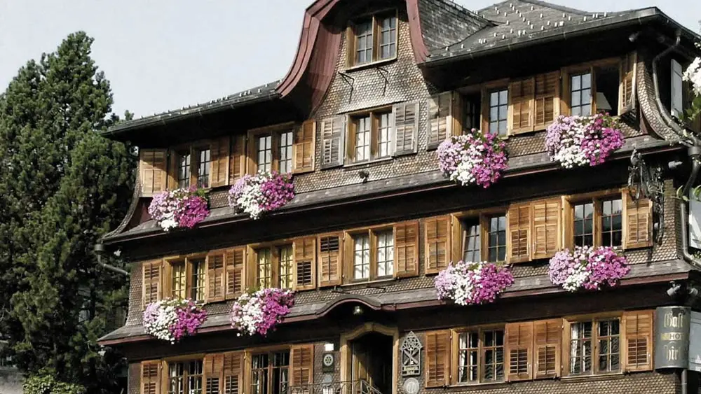 Historische Holzfassade des Hirschen in Schwarzenberg mit lila Blumen