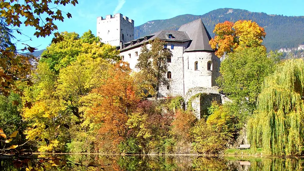 Außenansicht von Burg St. Petersberg an einem See in Silz