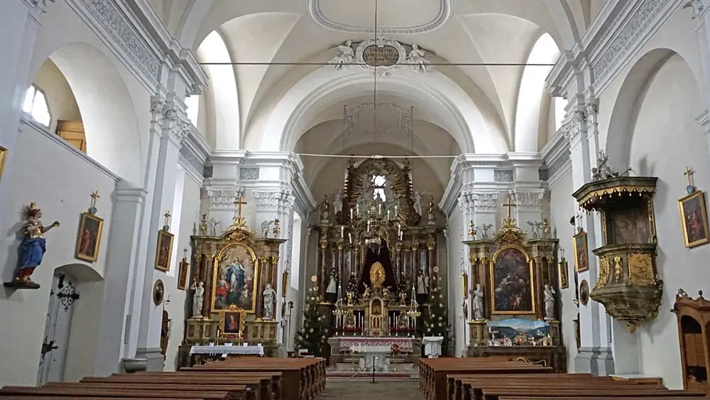 Blick in den Innenraum der Sterzinger St. Margarethenkirche mit Altären und Figuren