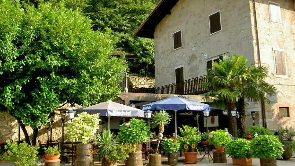 Außenansicht der Terrasse und des Restaurants Alla Grotta in Arco
