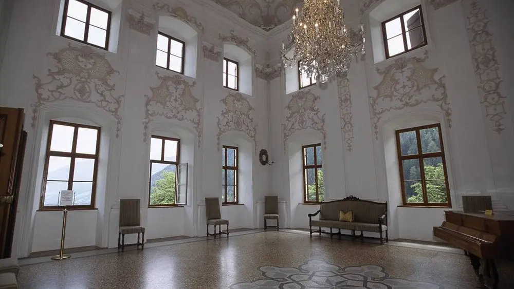 Blick in den barocken Ballsaal von Schloss Wolfsthurn mit Kristall-Kronleuchtern und Stuckarbeiten