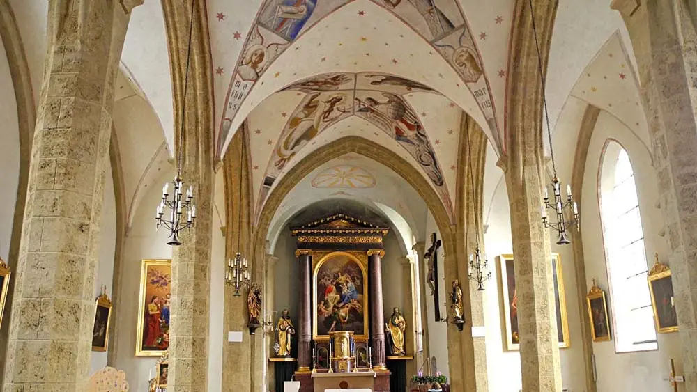 Innenraum von St. Vitus in Kufstein mit Deckengewölbe, Altar und Heiligenstatuen