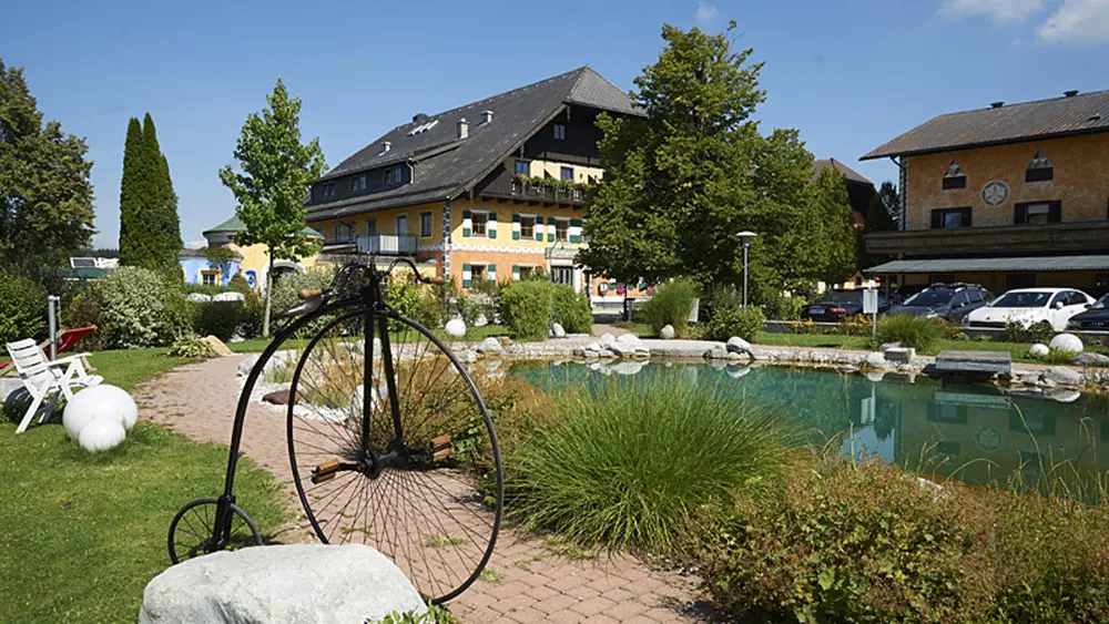Der Gastagwirt in Eugendorf mit Teich und altem Fahrrad im Vordergrund