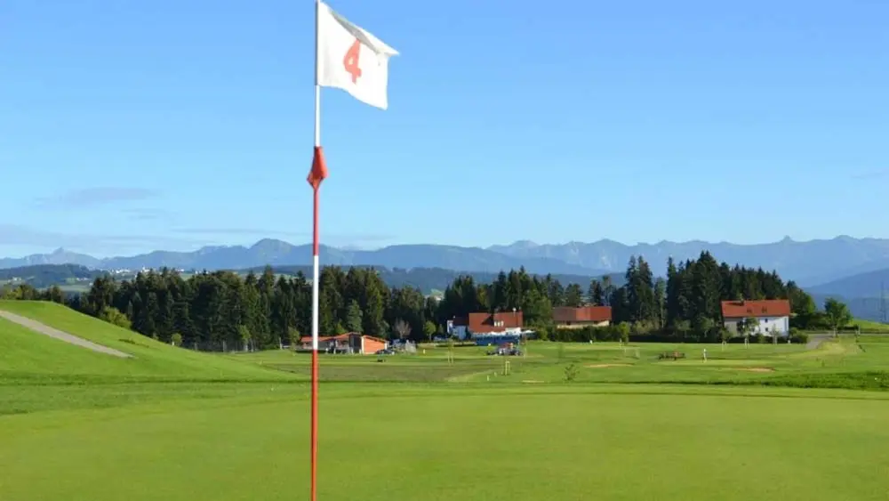 Loch auf dem Golfplatz Scheidegg, im Hintergrund die Bergkette der Allgäuer Alpen
