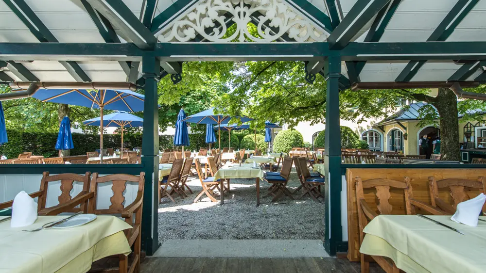Blick von der überdachten Terrasse in den Garten des Hotels Friesacher in Anif