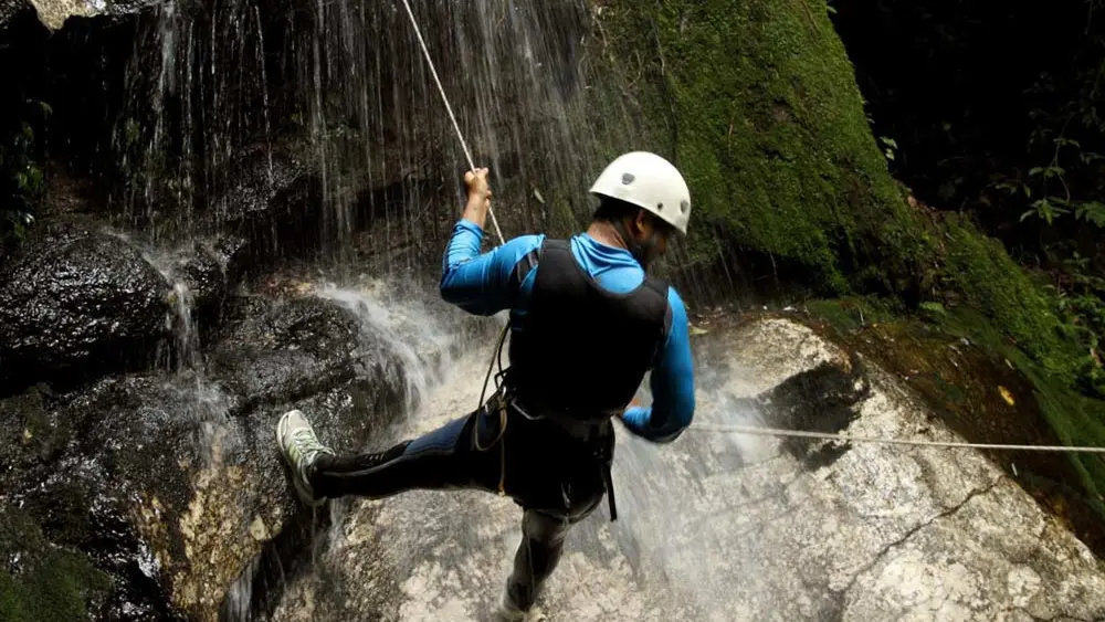 Mann an einem Wasserfall beim Canyoning