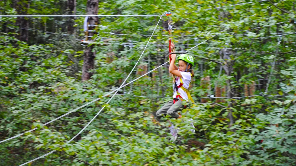 Mädchen auf der Zip-Line im Freizeitpark Busatte Adventure
