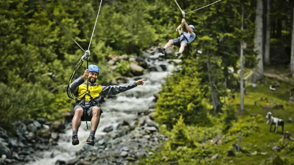 Personen an der Seilrutsche im Hochseilpark Saalbach Hinterglemm