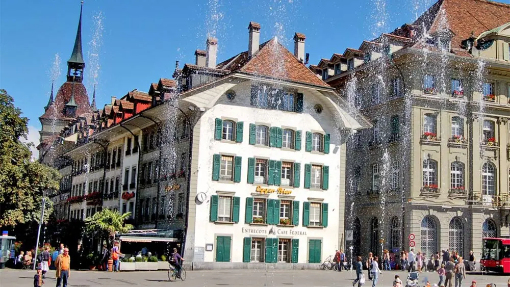 Der Bundesplatz mit Wasserspiel mit Blick auf das Gebäude des Entrecôte Café Fédéral