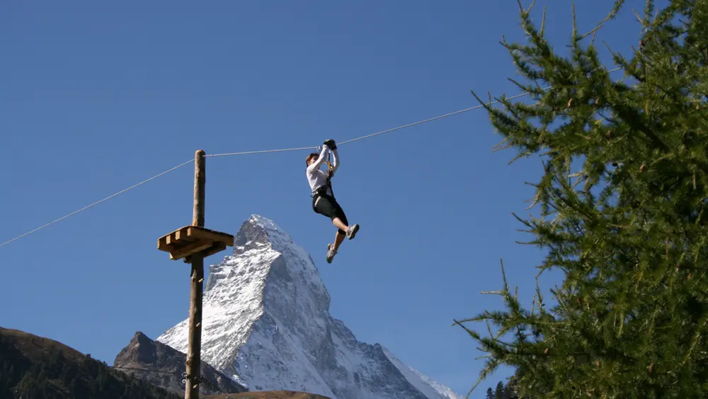 Besucher auf einer Zipline des Forest Fun Parks in Zermatt