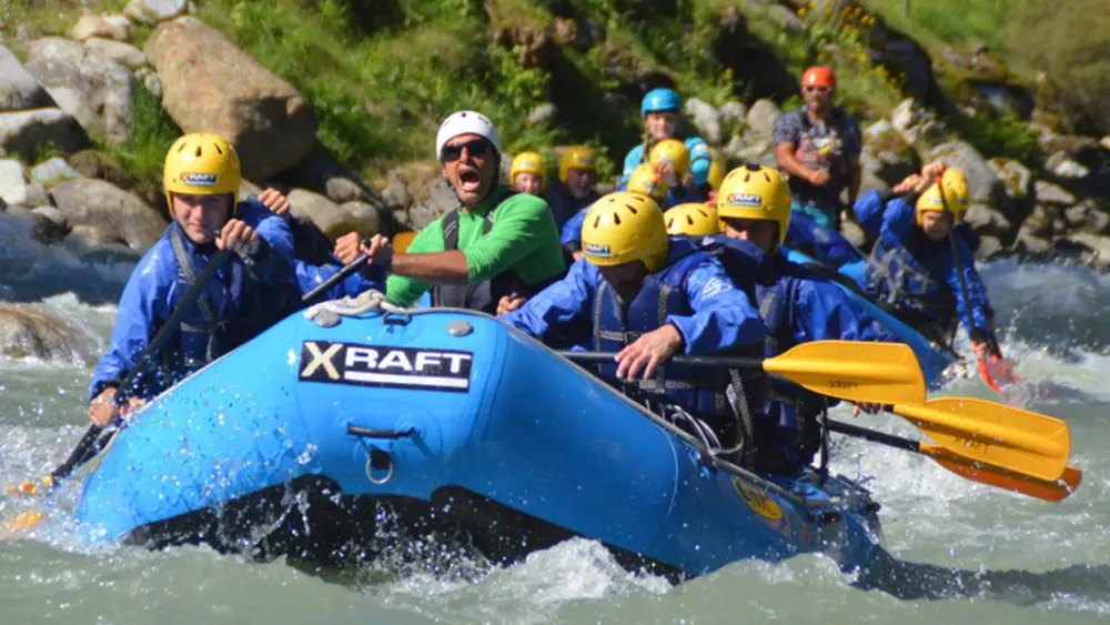 Gruppe in einem Raftingboot auf einem Fluss bei Mezzana