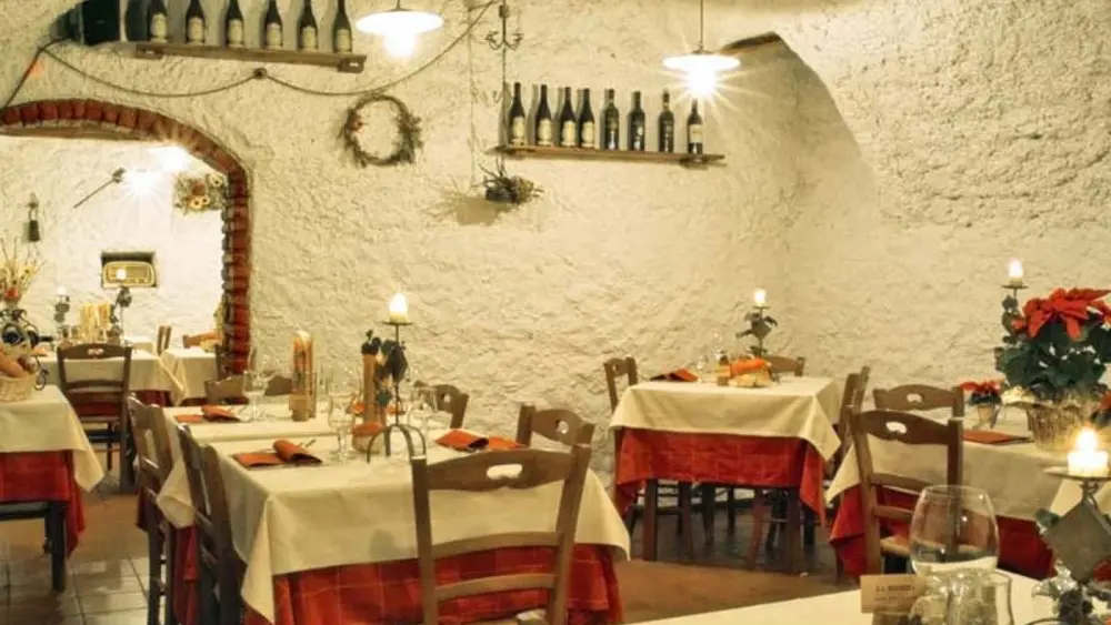 Blick auf die Tische im gemütlichen Speisesaal der Osteria La Miniera