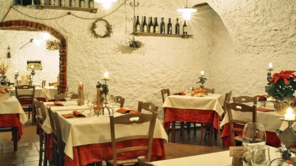 Blick auf die Tische im gemütlichen Speisesaal der Osteria La Miniera