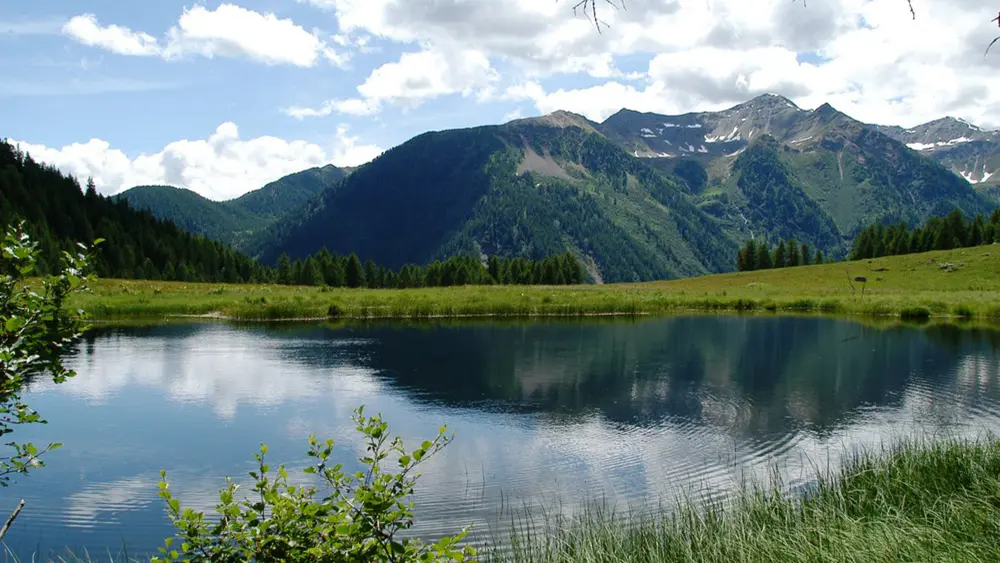Blick auf den von Bergen umgebenen Covel See im Val di Sole