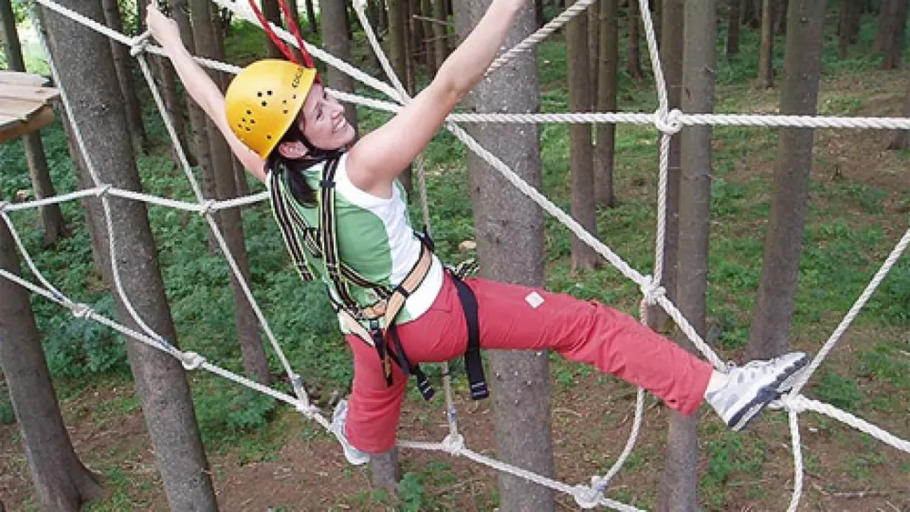 Kind beim Klettern im Waldseilgarten Höllschlucht in Pfronten