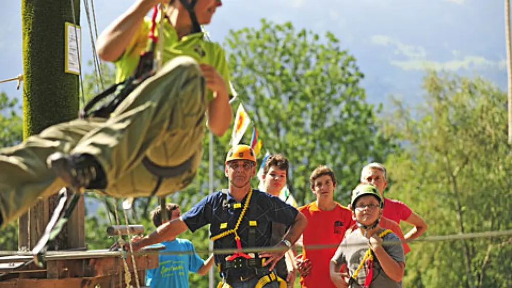 Mann auf der Seilrutsche im Seilpark im Forst in Triesen