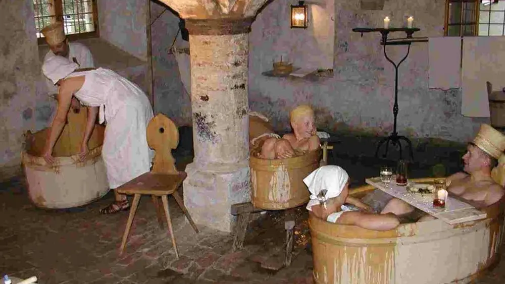 Menschen beim Baden in den Holzzubern der großen Badehalle der Wangener Badestube