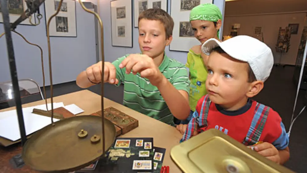Kinder beim Wiegen im Postmuseum Vaduz