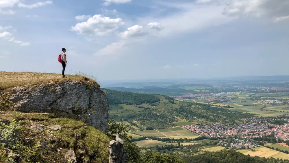 Eine Wanderin blickt auf dem Breitenstein in die Ferne