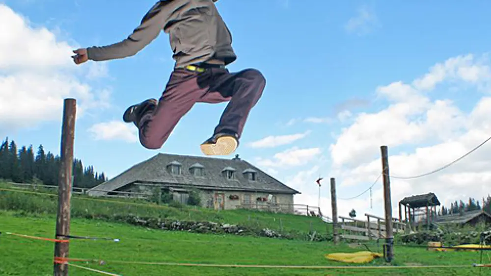 Mann auf einer Slackline im Slacklinepark in Mühlbach