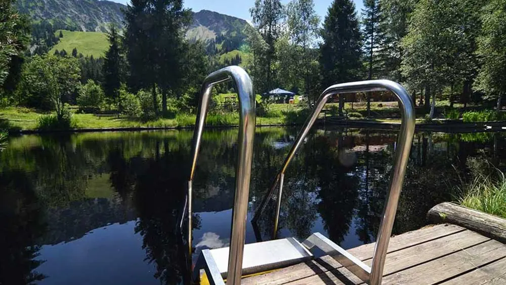 Blick vom Holzsteg auf das Wasser des Hochmoorbads in Oberjoch