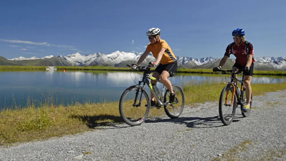 Mountainbiker am Ufer eines Gebirgssees im Gasteinertal