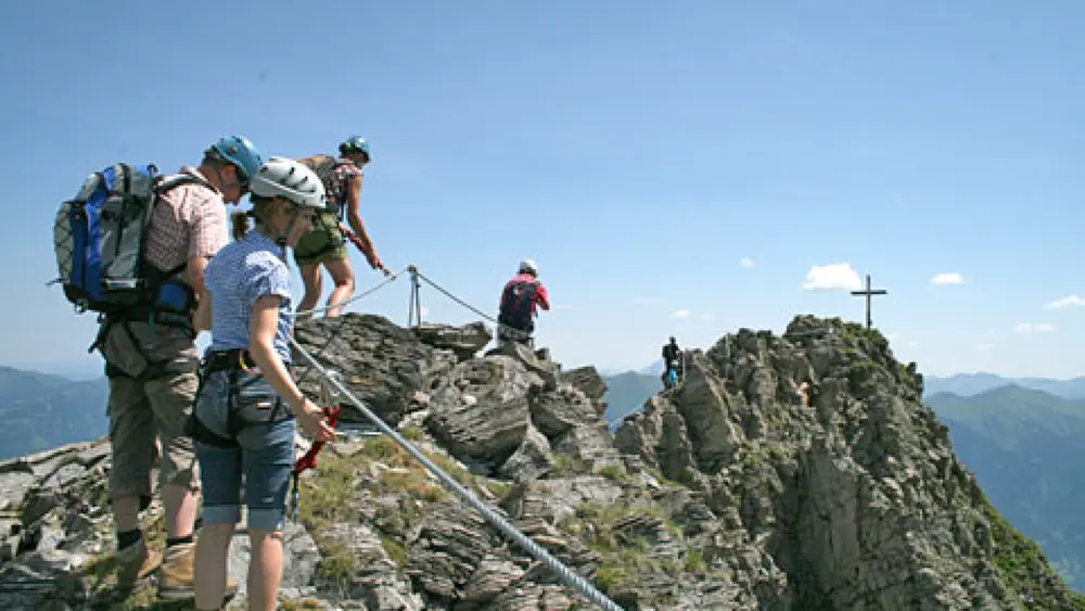 Kletterer auf einem Berggipfel-Klettersteig im Gasteinertal