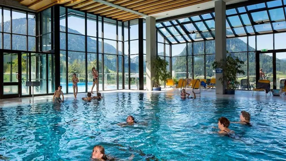 Badegäste schwimmen im Hallenbad des Alpenbads Pfronten