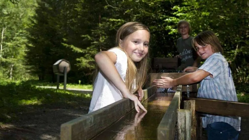 Kinder spielen an einer der Wasserstationen am Galetschbach bei Rettenberg