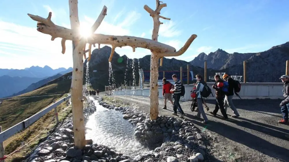 Wanderer passieren eine der Mitmach-Stationen entlang des Wasser-Erlebnispfades Burmiwasser
