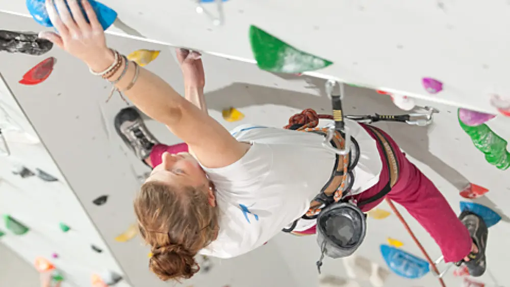 Frau an einer Wand in der Kletterhalle Felsenfest in Saalfelden