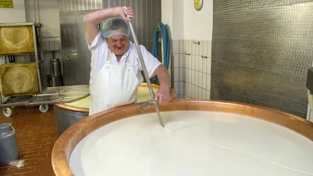 Senner beim Herstellen des Käsebruchs in der Sennerei Wertach