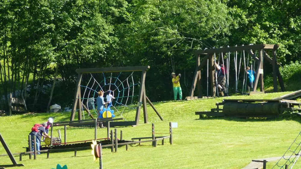 Kinder an den verschiedenen Stationen der Kletterwiese im Buron Kinderpark Wertach
