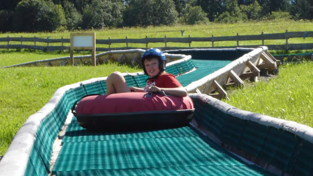 Kind auf der Reifenrutsche im Buron Kinderpark in Wertach