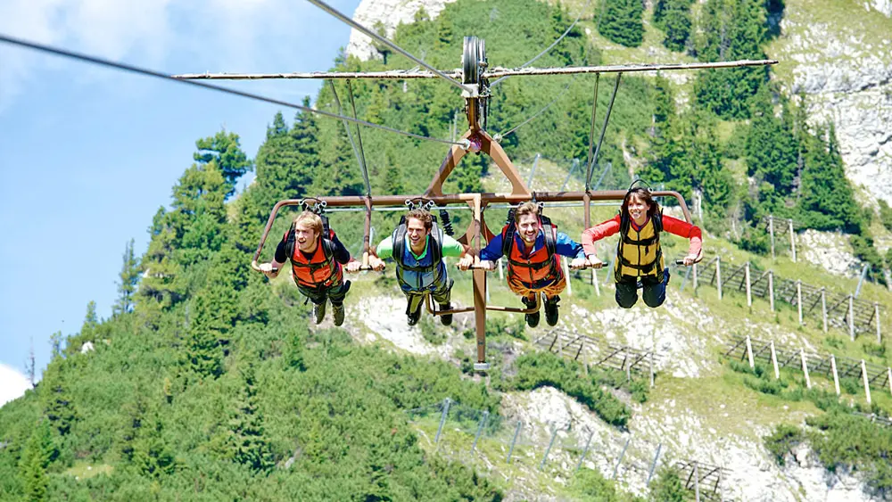 Vier Menschen im Skyglider AIRROFAN an der Bergstation der Rofanseilbahn