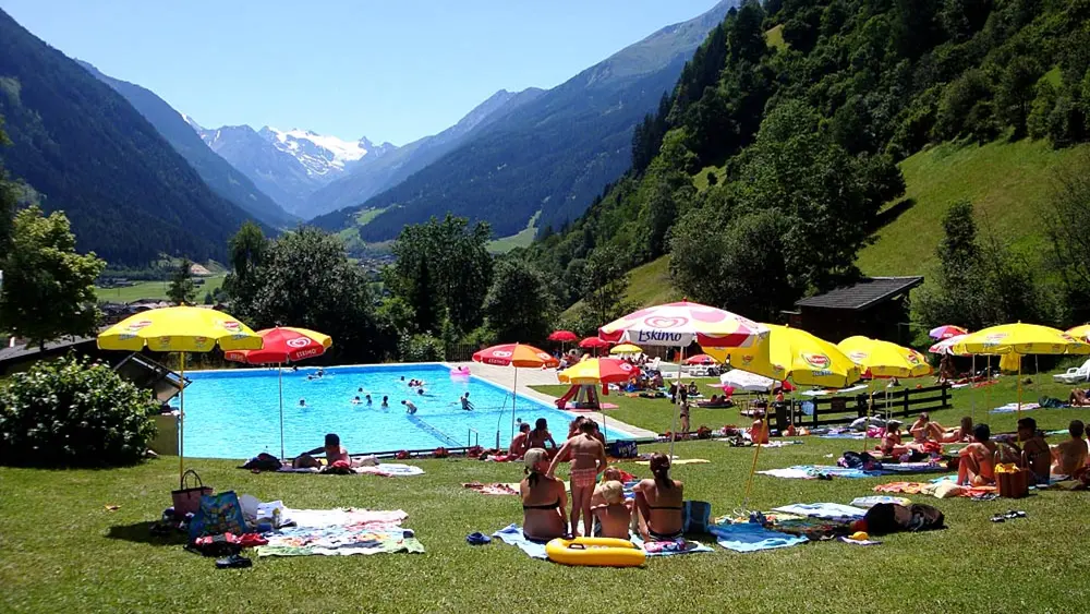 Blick auf die Liegewiese und das Außenbecken im Freibad Neustift