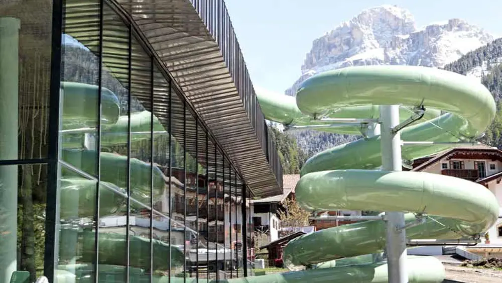 Die 111 m lange Röhrenrutsche der Aquarena Dolaondes in Canazei, im Hintergrund die Dolomiten