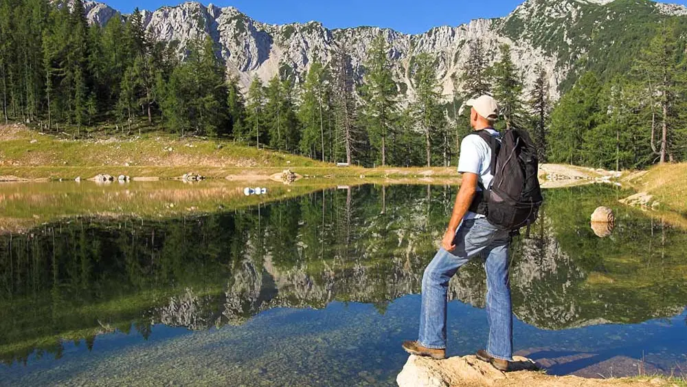 Wanderer vor einem Bergsee am Petzen