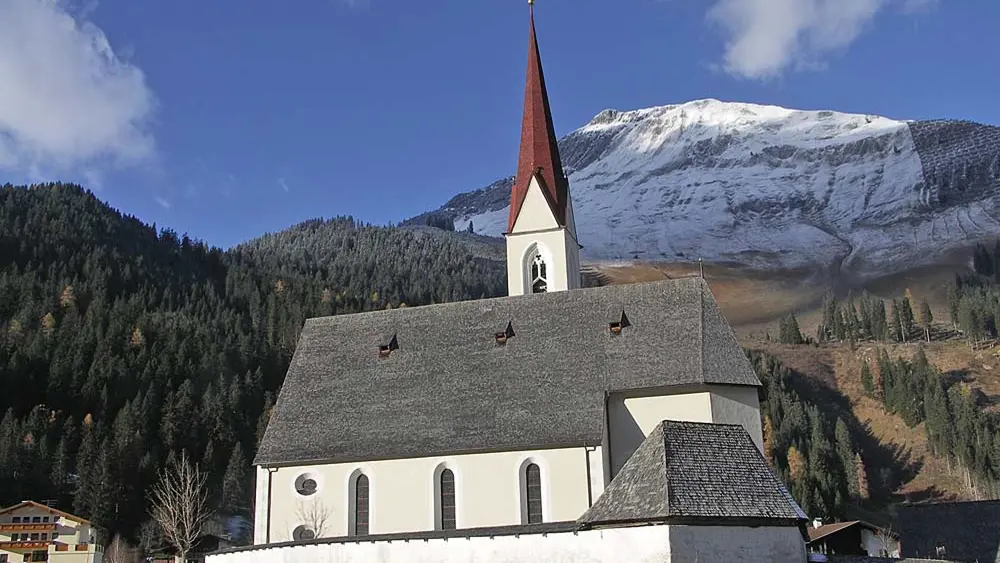 Blick auf die Pfarrkirche Sankt Nikolaus mit Friedhofskapelle in Elbigenalp