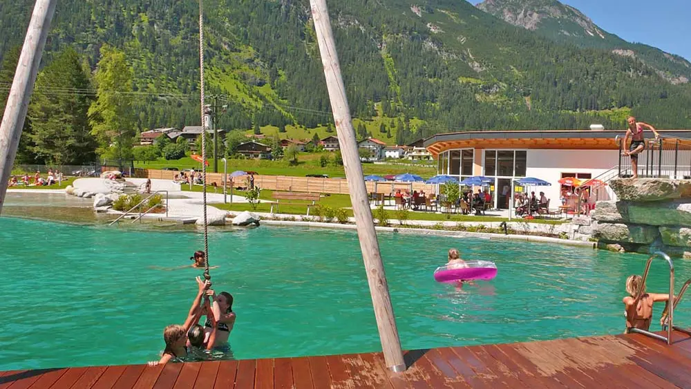 Blick auf den Badeteich und den Natursprungfelsen im Naturerlebnisbad Badino