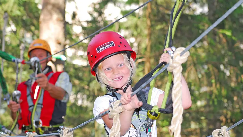 Kind beim Klettern am Kiddyparcours im Kletterwald Tannheimer Tal