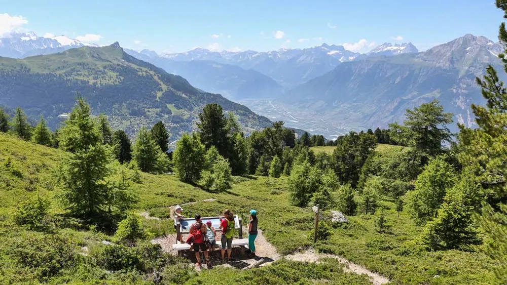 Familie an einer Schautafel mit Bergpanorama am Panoramaweg Nendaz