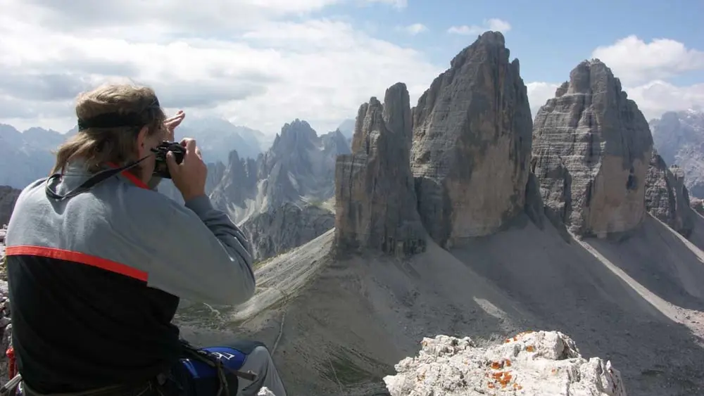Kletterer auf dem Gipfel des Paternkofel fotografiert die Drei Zinnen