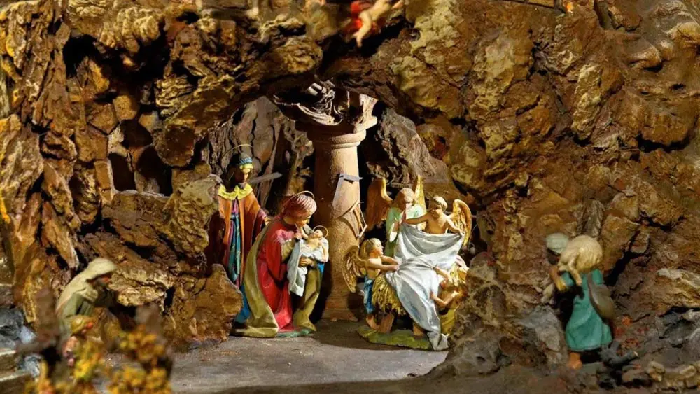 Maria und Josef mit Jesus und Engeln in einer Felsenhöhle der Krippenausstellung Anton Stabinger in Sexten
