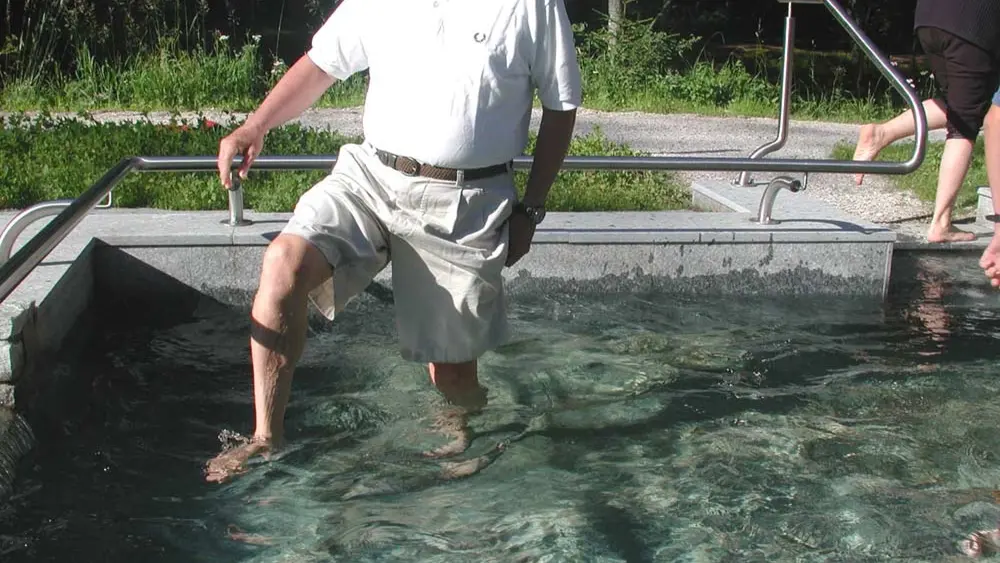 Mann im Wassertretbecken des Kneipp Erlebnisdorfs Niederdorf
